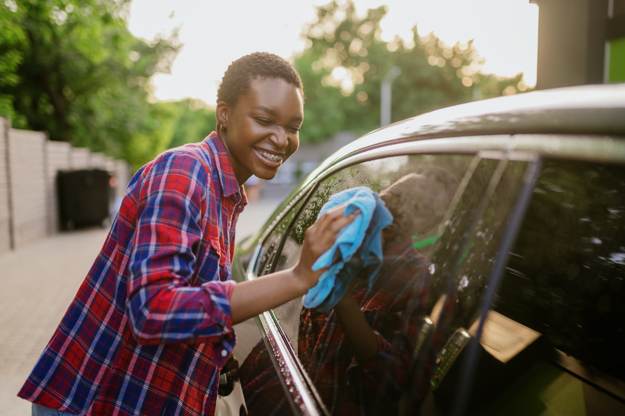 Woman wipes a car with rag, hand auto wash. Santa Barbara Rescue Mission.